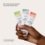 Hand holding Daily Electrolytes packets beside mixing instructions
