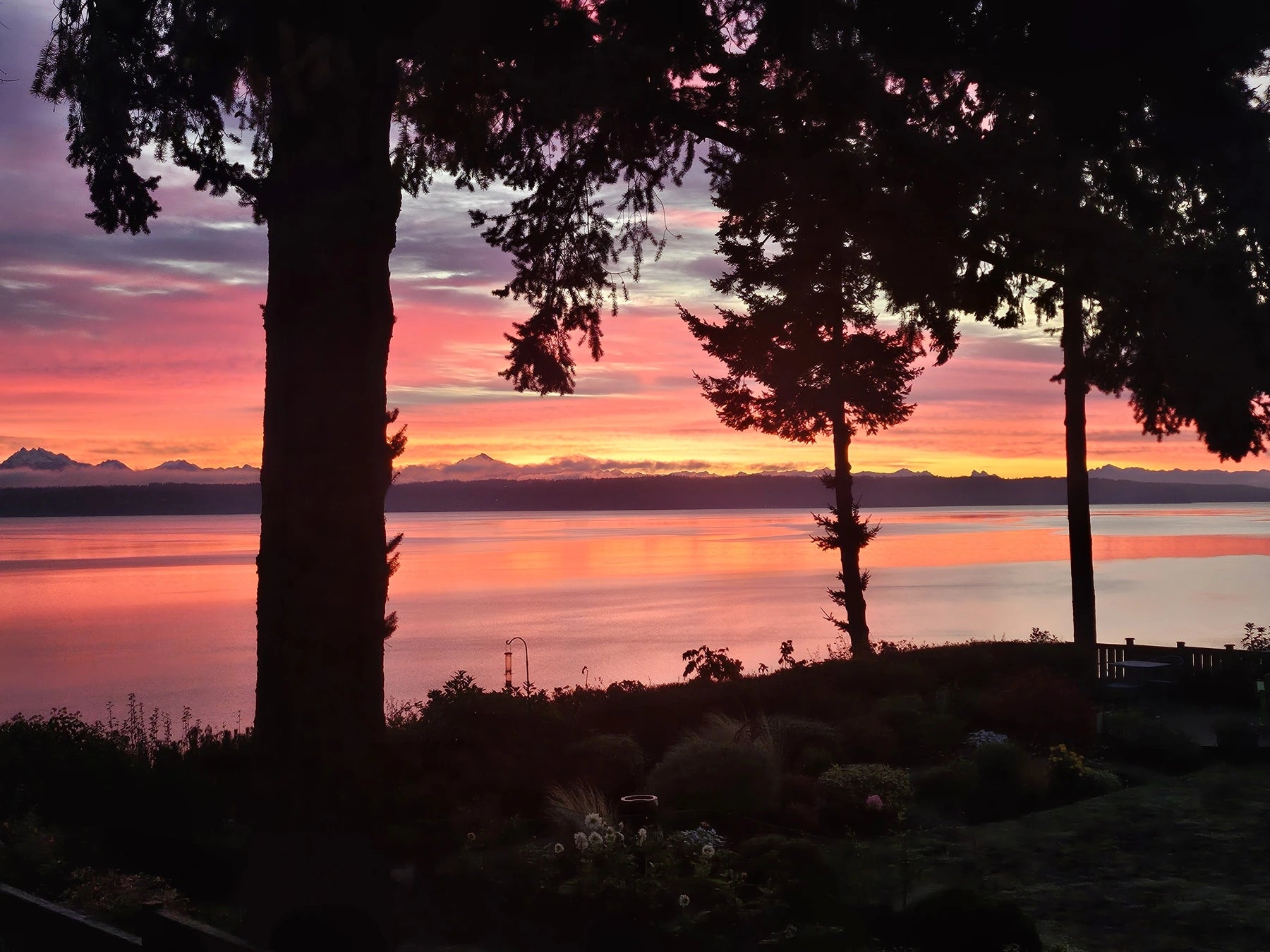 Sunrise over the water and mountains from Preston’s deck